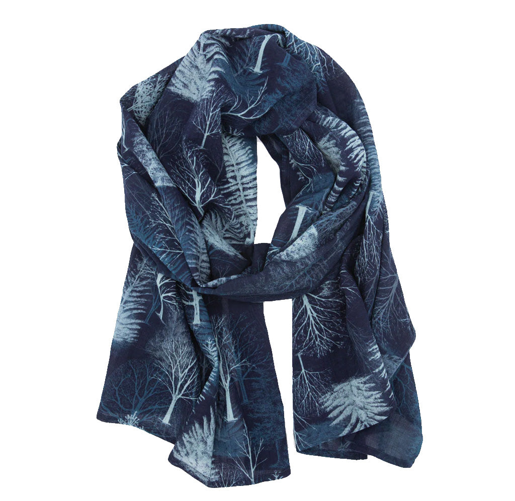 A blue scarf with light blue trees and branches printed all over the fabric. 