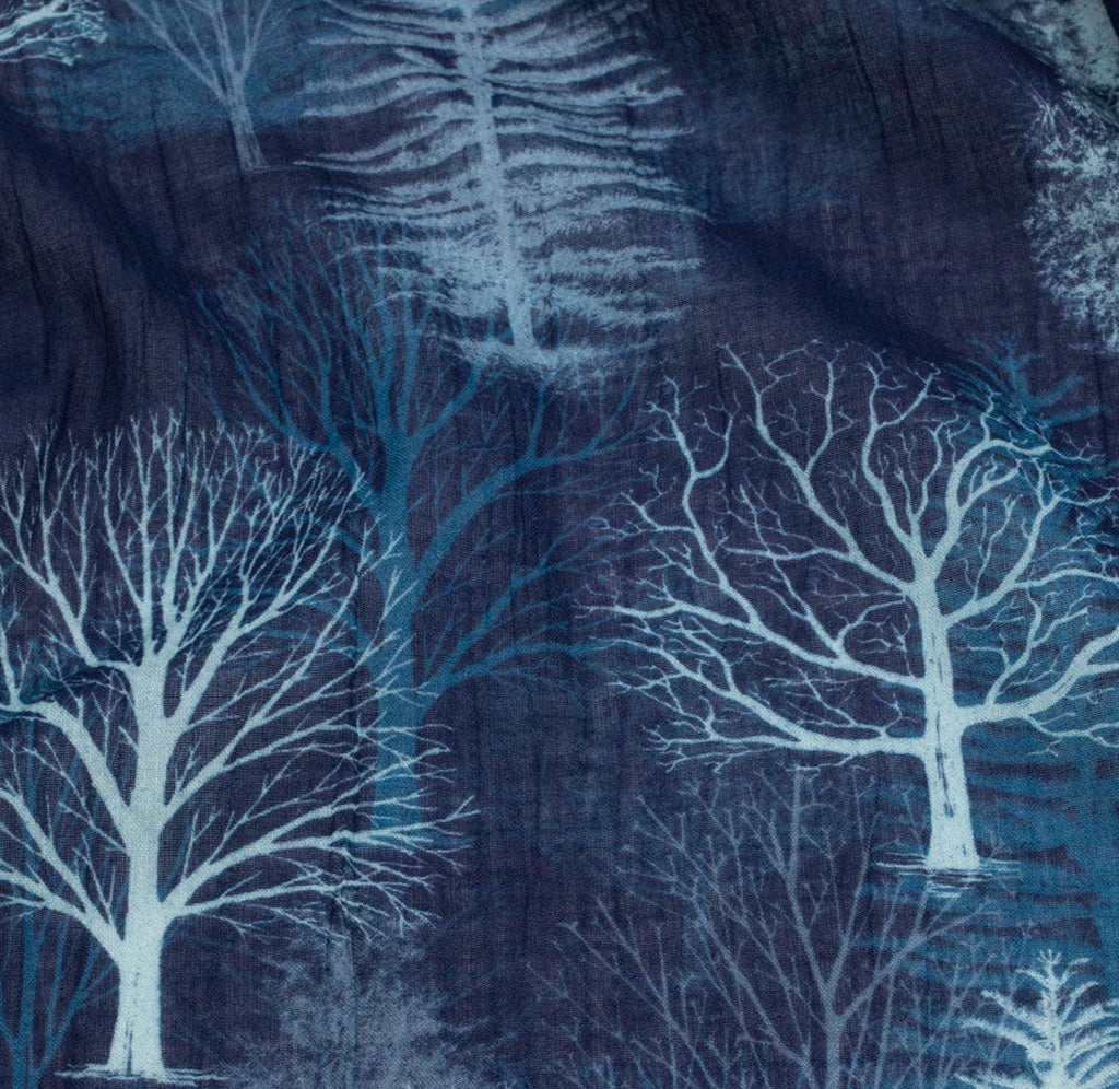 Close up of the scarf pattern with blue background and a light blue tree motif printed on top. 