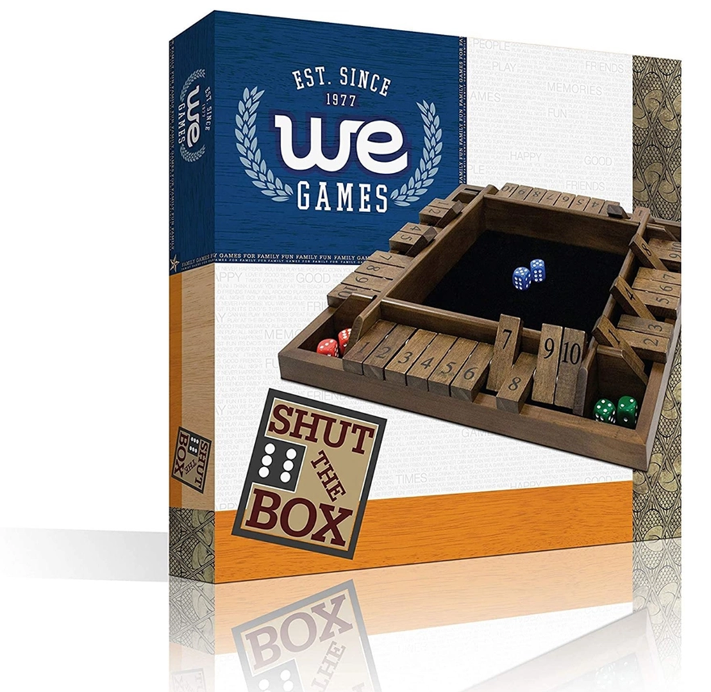 “Shut the Box” tabletop game by We Games: a wooden numbered tray with dice sits in front of its blue-and-orange box, evoking classic family fun.
