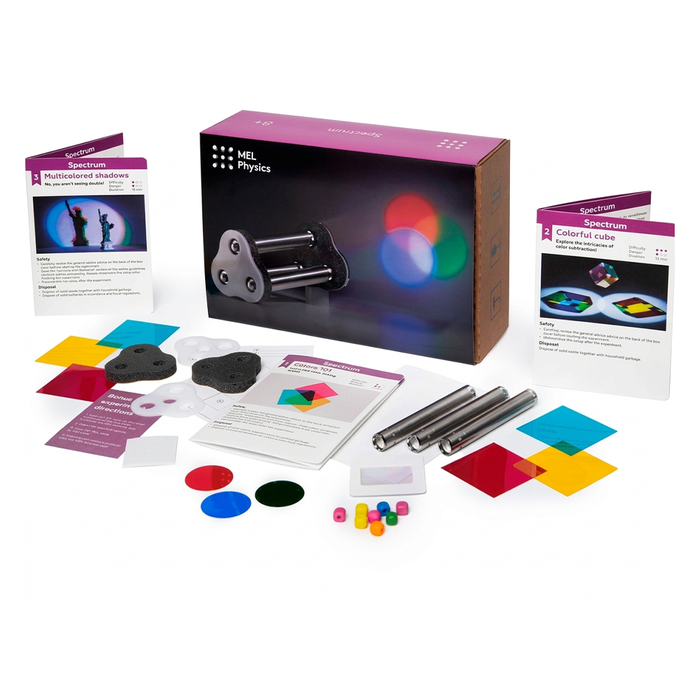 A MEL Physics light and color experiment kit is displayed with a black box, spectrum guides, metal tubes, colored filters, discs, and small components, suggesting hands-on science learning.