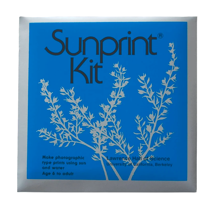 A blue Sunprint Kit package shows white botanical silhouettes and text about making photographic prints with sunlight and water, with a clean, educational tone.