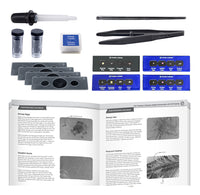 A flat-lay product shot of a microscopy kit and instruction booklet. The kit includes a microscope slide cover, specimen covers, a dropper, forceps, two small vials, a small box, several gray slide holders, blue specimen cards, and an open instruction booklet showing text and microscopy images.