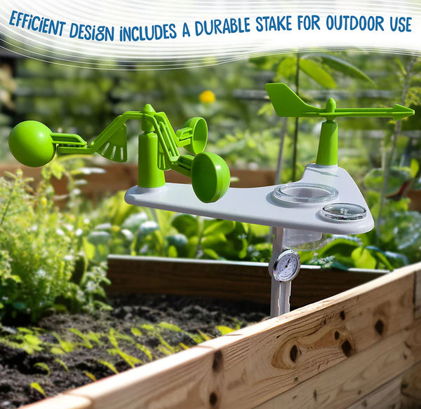 A green and white outdoor weather station with a wind vane, anemometer, and thermometer, shown planted in a wooden raised garden bed with a blurred garden background. Text at the top reads 'EFFICIENT DESIGN INCLUDES A DURABLE STAKE FOR OUTDOOR USE'.