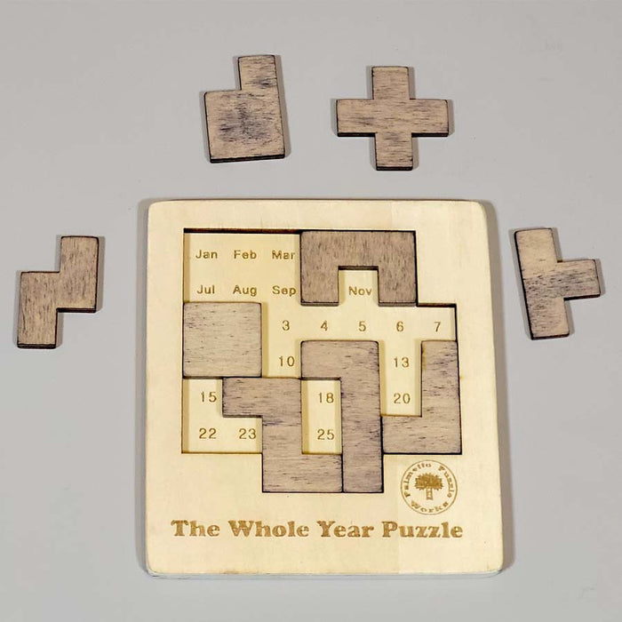  The Whole Year Puzzle is a wooden puzzle with different shapes lie outside the pzzle and inside showing the months and dates in a year. 