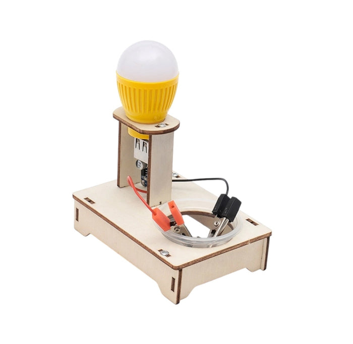 A DIY laser-cut wooden science experiment kit with a light bulb circuit. The kit features a light wood base, a vertical wooden stand, a yellow light bulb, and red and black wires with alligator clips on a white background.