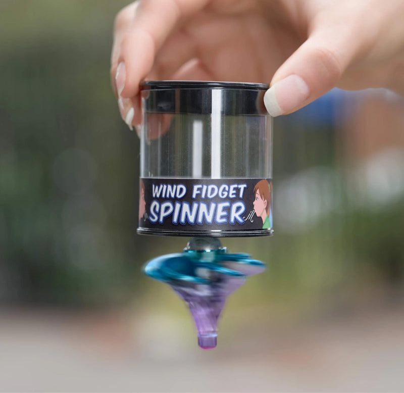 Hand holding a top spinning upside down on a cylindrical package. 