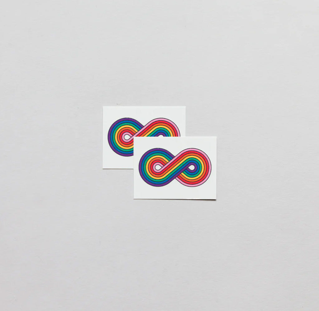 Two pieces of paper, each with an infinity symbol colored with rainbow colors. 