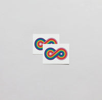 Two pieces of paper, each with an infinity symbol colored with rainbow colors. 