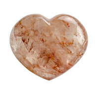 Heart-shaped stone with a red marbled pattern on a white background