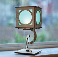 Wooden lantern with blue panels on a stand, blurred window background