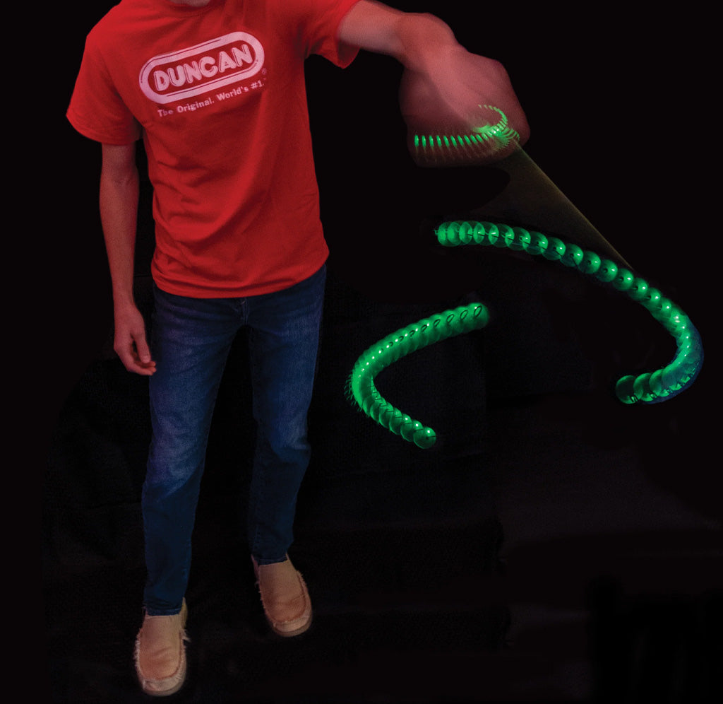 Person wearing a red Duncan t-shirt with a green glowing toy on a black background