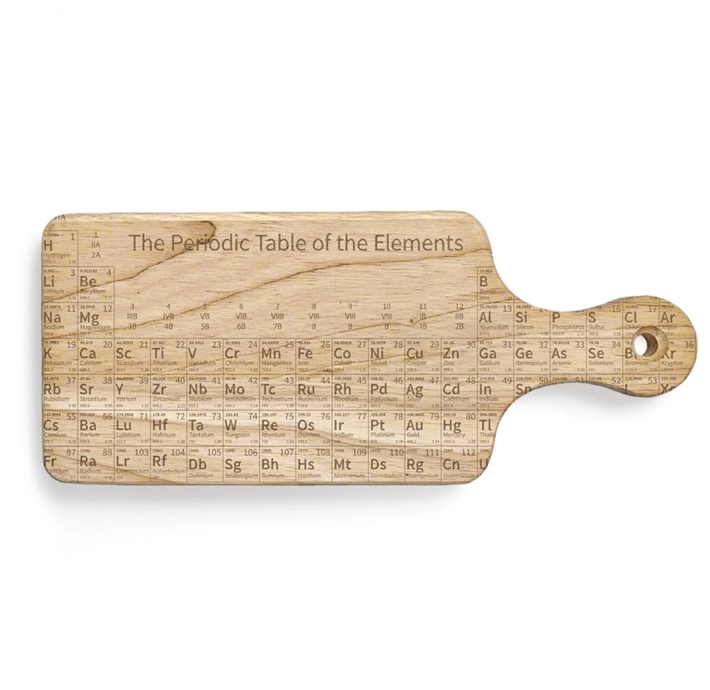 A wooden cutting board with the periodic table of elements engraved on the surface. 