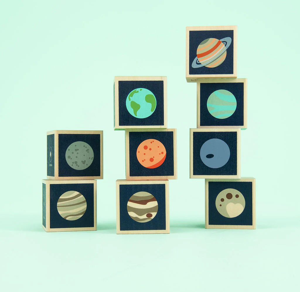 Stack of wooden blocks with planet illustrations on a light green background