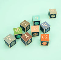 Set of colorful dice with astrological symbols on a light green background