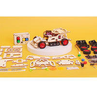 Educational DIY car kit with wooden components and electronic parts on a yellow background