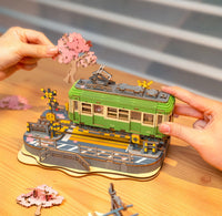 Wooden tram kit being assembled on a table.