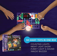 Hands playing with a toy circuit board set on a dark surface, with the toy box visible.