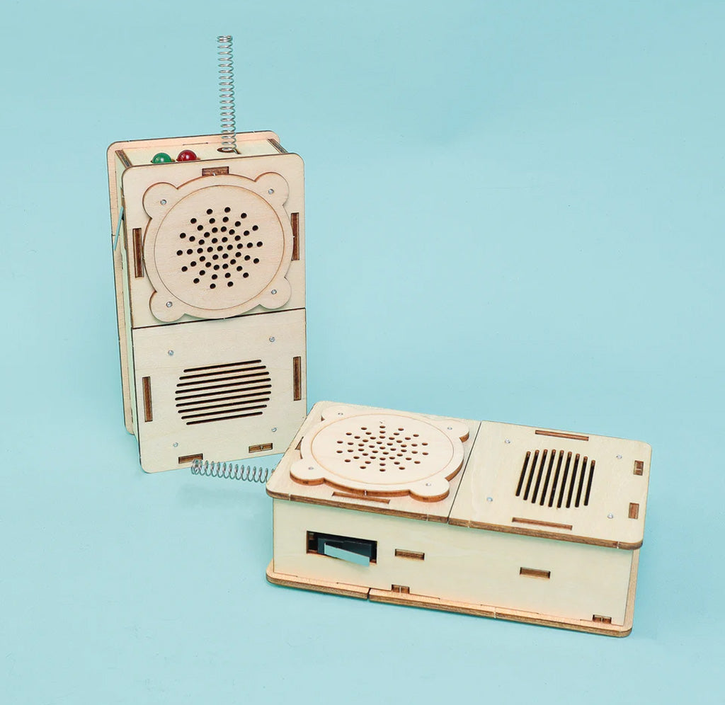 Two wooden toy walkie talkies on a light blue background