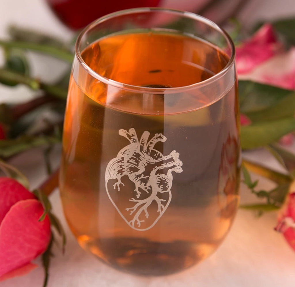 A stemless wine glass filled with red sangria; a silver anatomical in metallic platinum ink on the front.