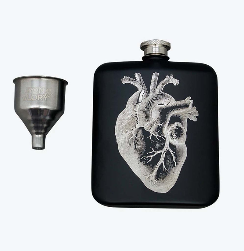 Black coated stainless steel hip flask with a silver anatomical heart on the front. A silver funnel sits to the left. The mouthpiece at the top of the flask is stainless steel.