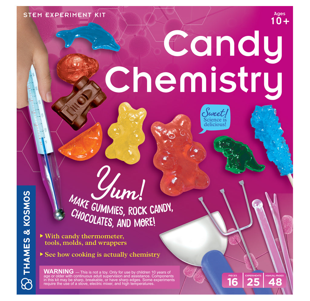 A bright pink package showcasing the different candies that can be made with the kit, large red and yellow gummy bears, blue rock candy, chocolate car, and red candy skull, for example. Tools and candy-making thermometer. 