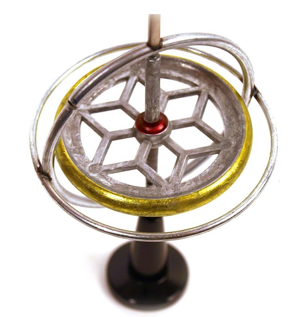 Silver and gold mounted disc with a star pattern in gimbal rings sit on a black stand.