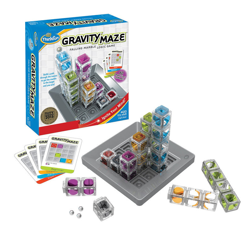  A product box sits in the background; Gravity Maze is set up in the foreground, a grey grid with towers of varying color and height sits on the grid. A few fallen towers and challenge cards lie to the side.
