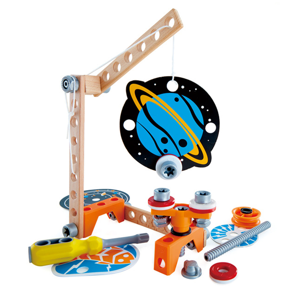 A black and blue planet hangs from a wooden crane; under the planet are three magnets that move around to spin the planet. Several tools, magnets, and discs are scattered underneath.