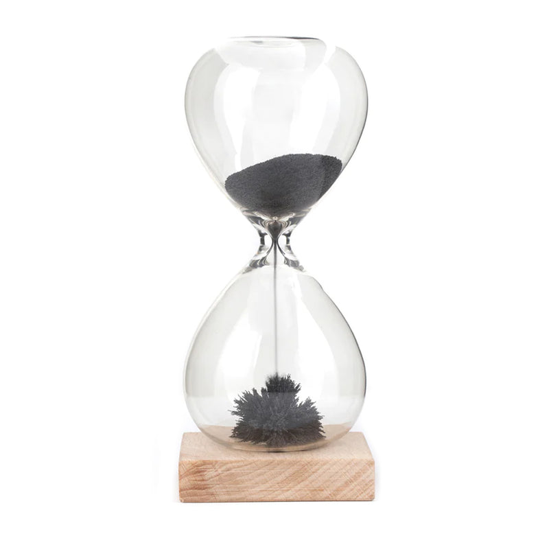A glass hourglass with a magnetic wood base; as the magnetic black sand moves through the hourglass, it creates little porcupine-like spikes as it becomes magnetized.
