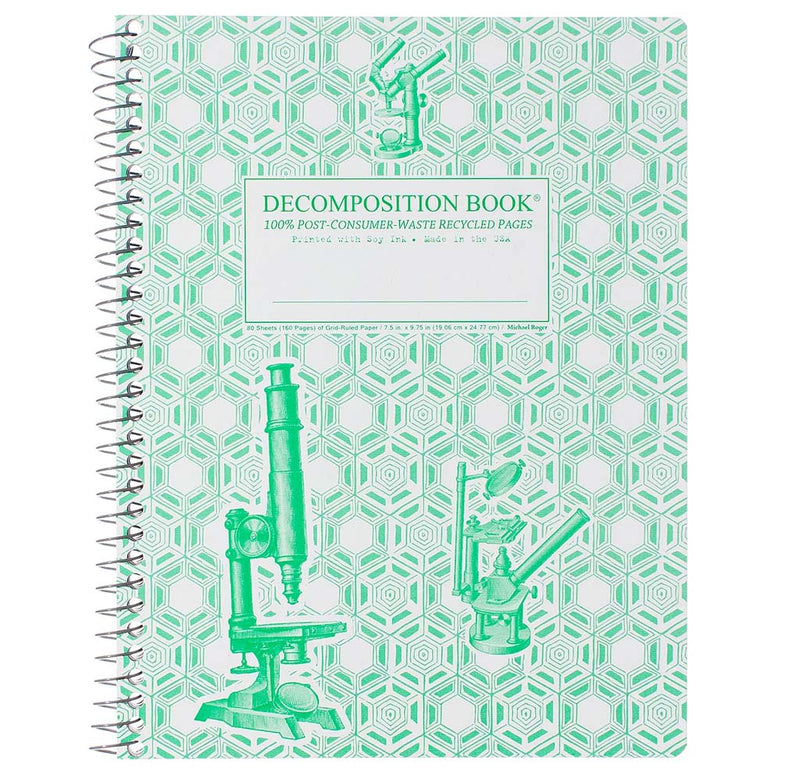 A spiral-bound notebook with a green and white pattern across the cover with science instruments, a microscope, a Bunson burner, and a magnifier in green.