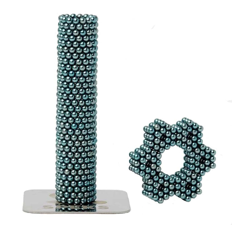 A cylindrical tube and small star in the teal Moonstone Luxe Speks.