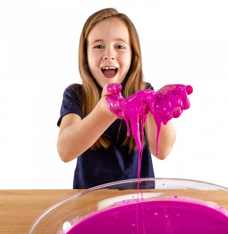 A young girl is scooping the pink-colored oobleck into her hands.