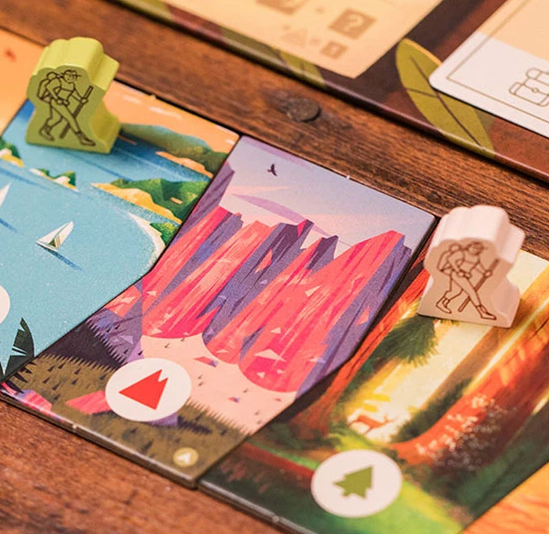    Two wooden hikers are moving across the game board across different National Parks.