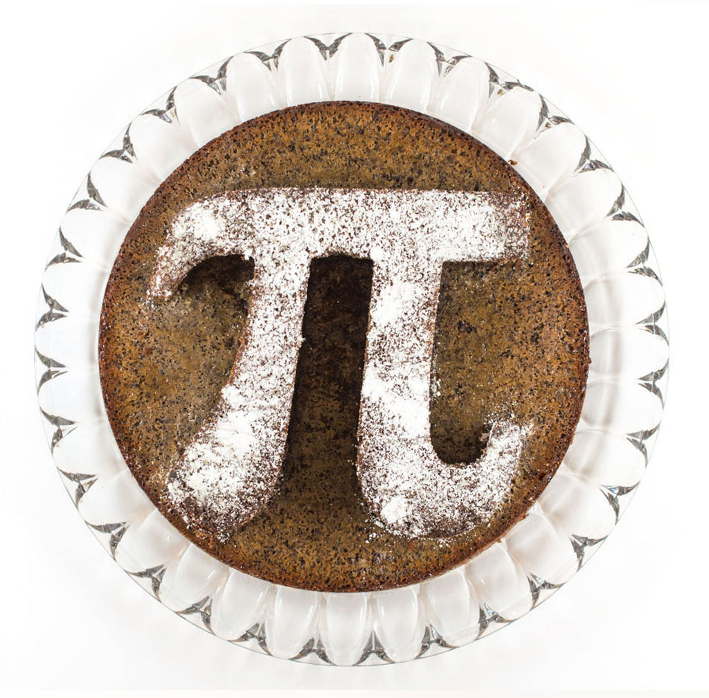 A clear cake dish with a Pi symbol brown sugar cake dusted with powdered sugar.