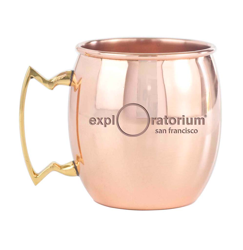The Exploratorium Pi Shrine Moscow Mule Mug is a copper mug with a brass handle. The Exploratorium's logo, San Francisco, is etched across the back.