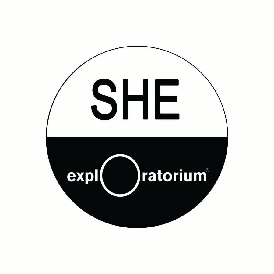 She pronoun pin in all caps in black text against a white background on the top half of the pin. Exploratorium in white text against a black background.