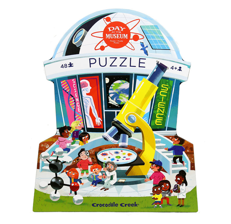  A rotunda-shaped box with different colorful illustrations representing all the activities at a science museum sits against a white background. Some of the items found are a microscope, an atom molecule, a telescope, and DNA strands. 