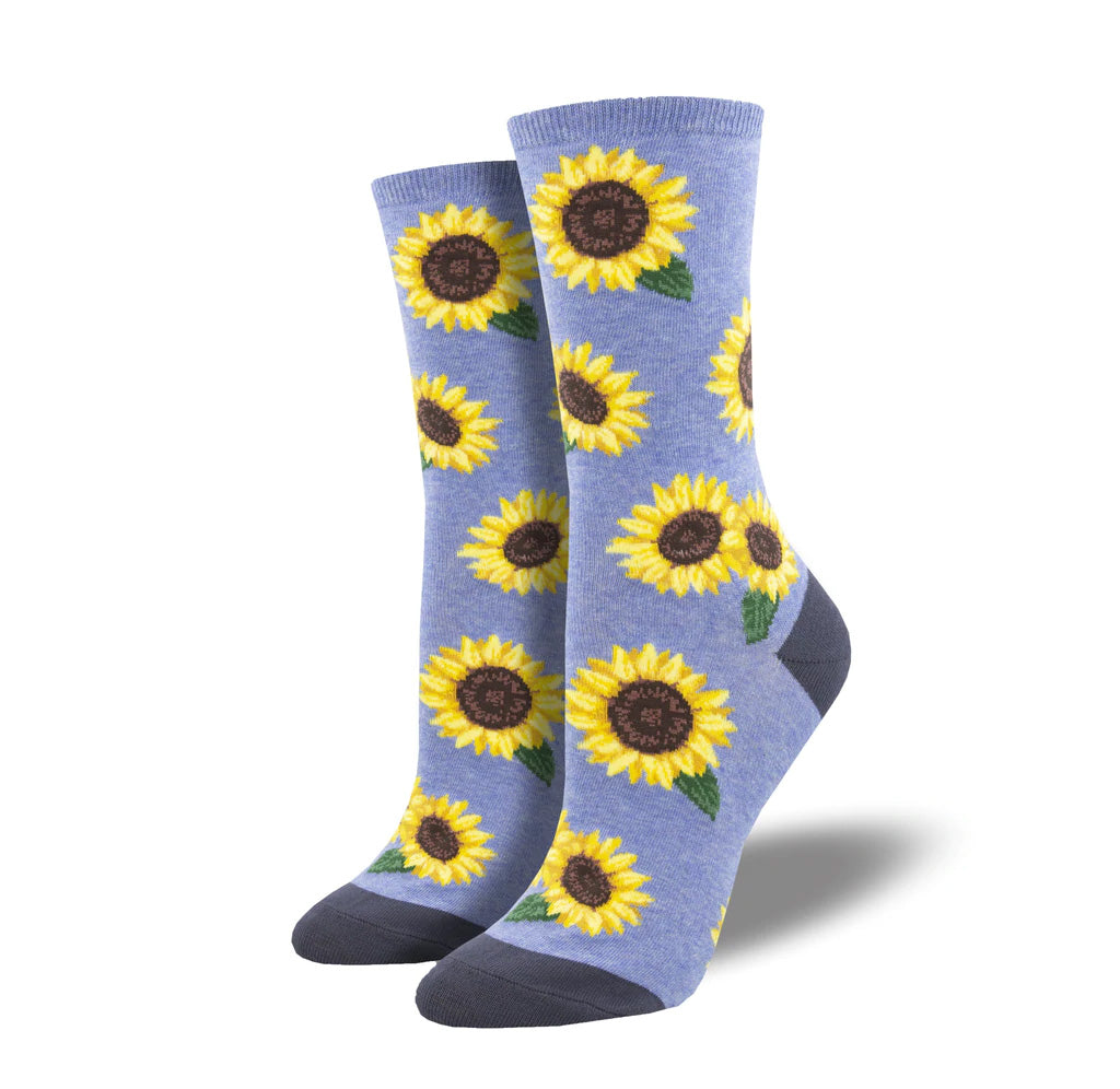 A blue sock with dotted with large sunflower heads; the toes and heels are a darker blue.