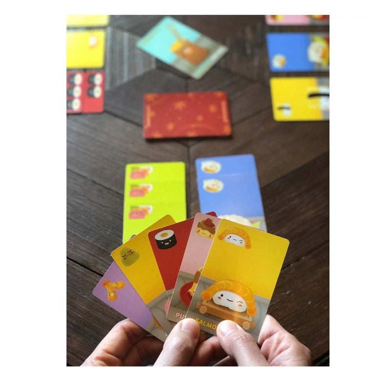 Sushi Go! Set up for play; the player's hand is facing forward, and there are several stacks of cards in different directions on the table.