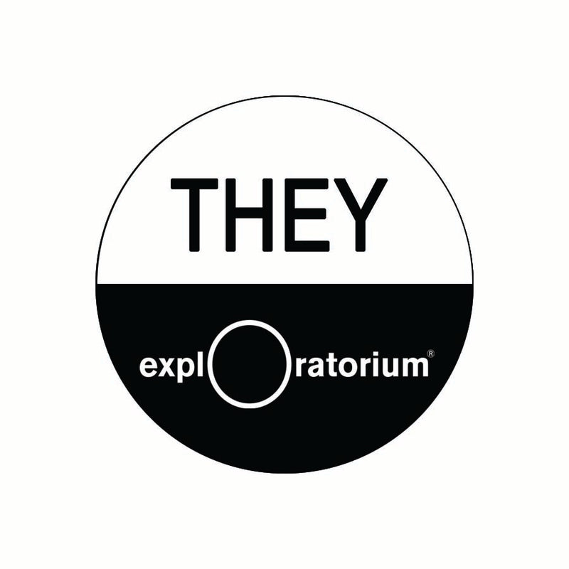 They pronoun pin in all caps in black text against a white background on the top half of the pin. Exploratorium in white text against a black background.