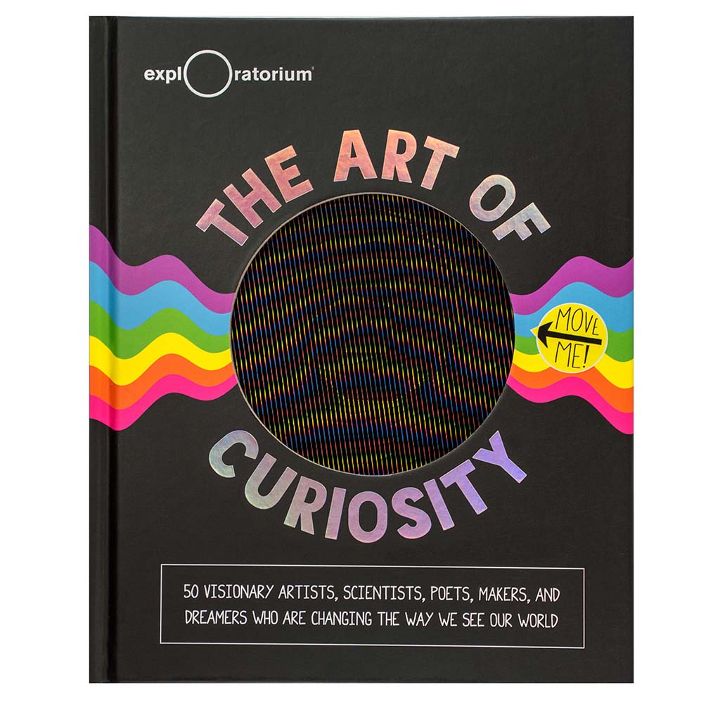 "The Art of Curiosity" is a hardcover book; there is an optical illusion sheet that can come out of the book and be used with experiments. There is a rainbow radiating outward from the middle. The text is shiny silver.
