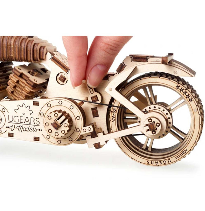 An extraordinarily detailed and precise motorcycle made from wood close up of the little nut tool turning the nut to tighten it.