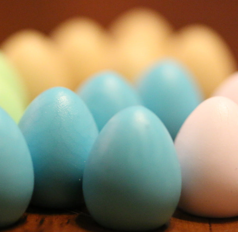 Close-up image of gameplay pieces of eggshell blue and white eggs.