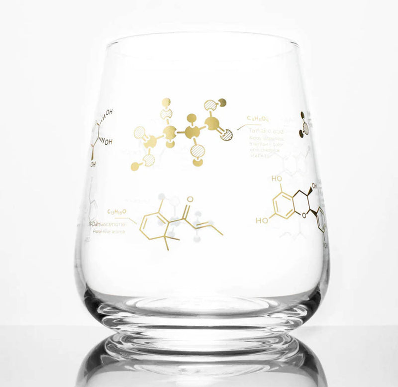 A stemless wine glass with the molecules and formula for wine in gold ink.