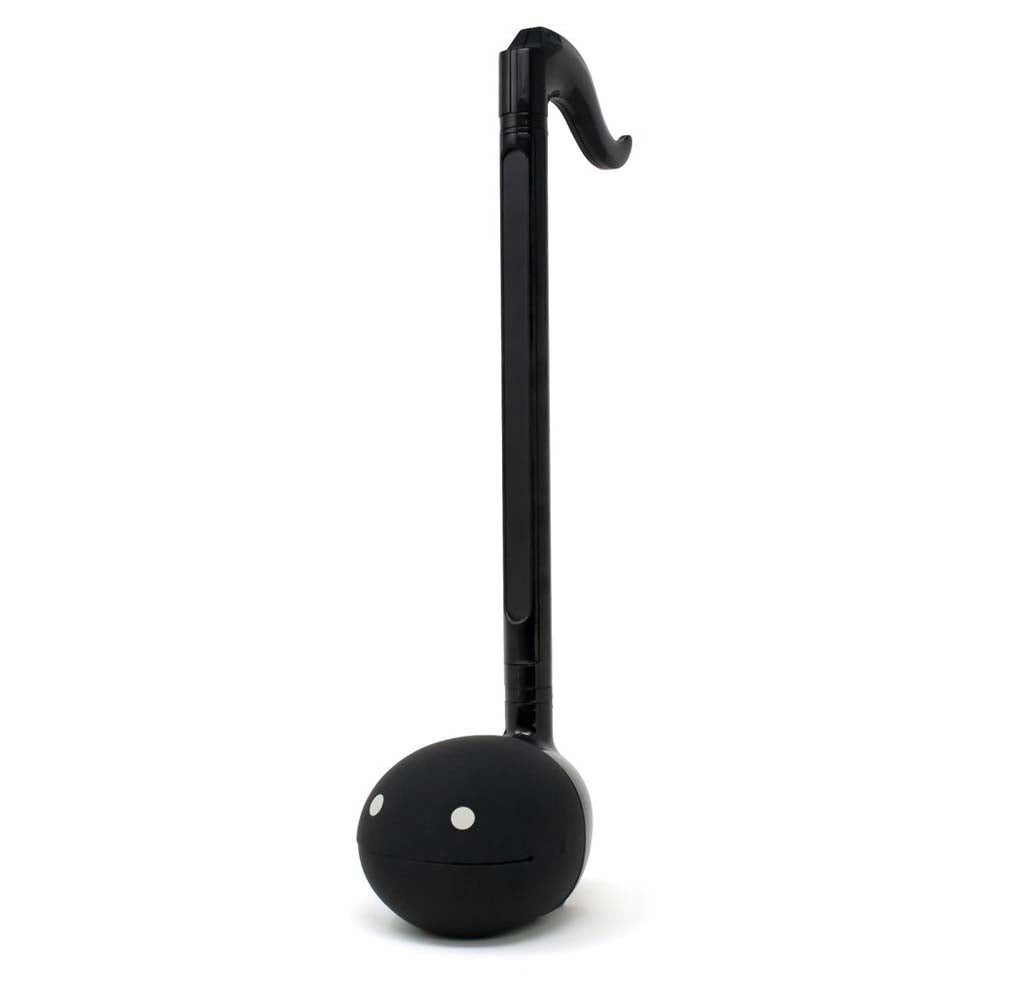 A long slender black musical instrument that is in the shape of an eighth note with white eyes on the base. 
